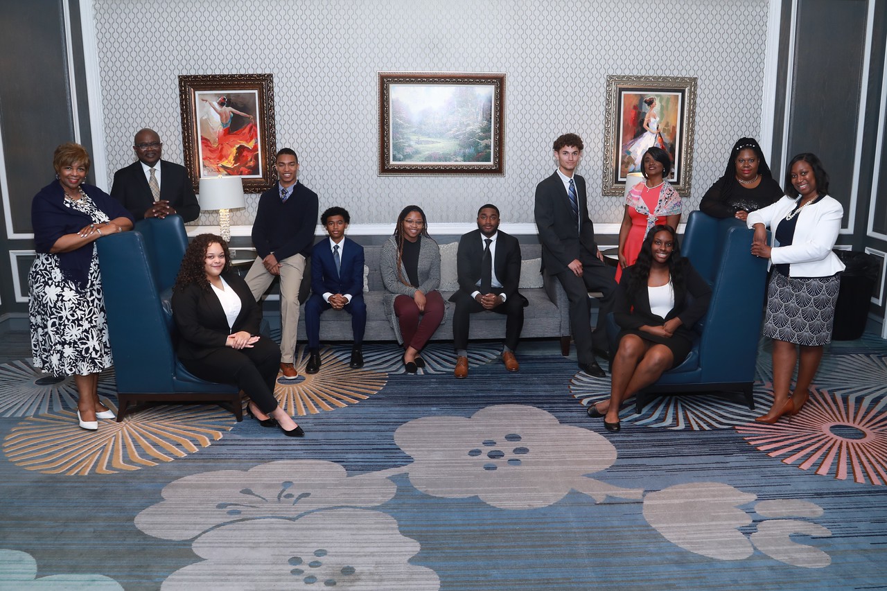 A group of people sitting in chairs and posing for the camera.